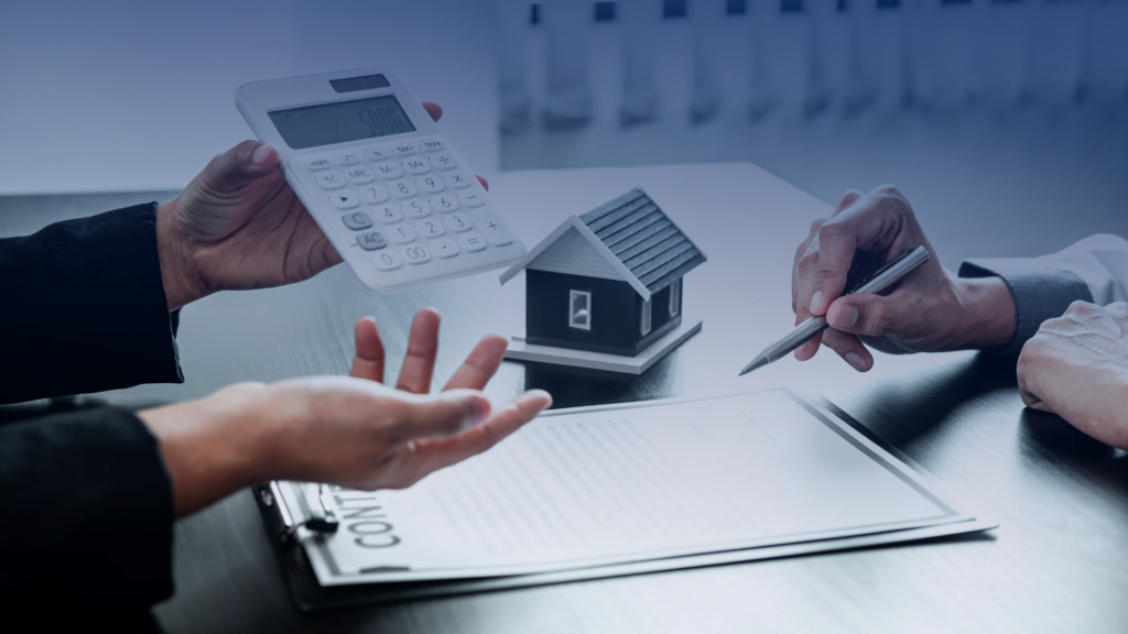 Close-up of hands exchanging a calculator and a model house over a real estate contract, illustrating the finalization of an FHA loan agreement.